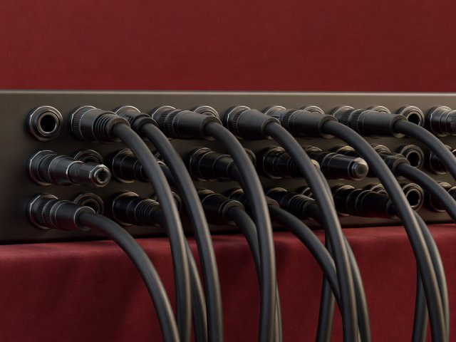 Softly lit 3D patchbay connectors and balanced audio jacks on a warm burgundy background